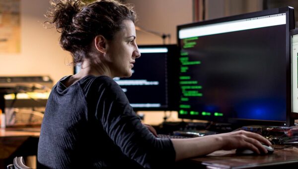 woman looking at code on a computer